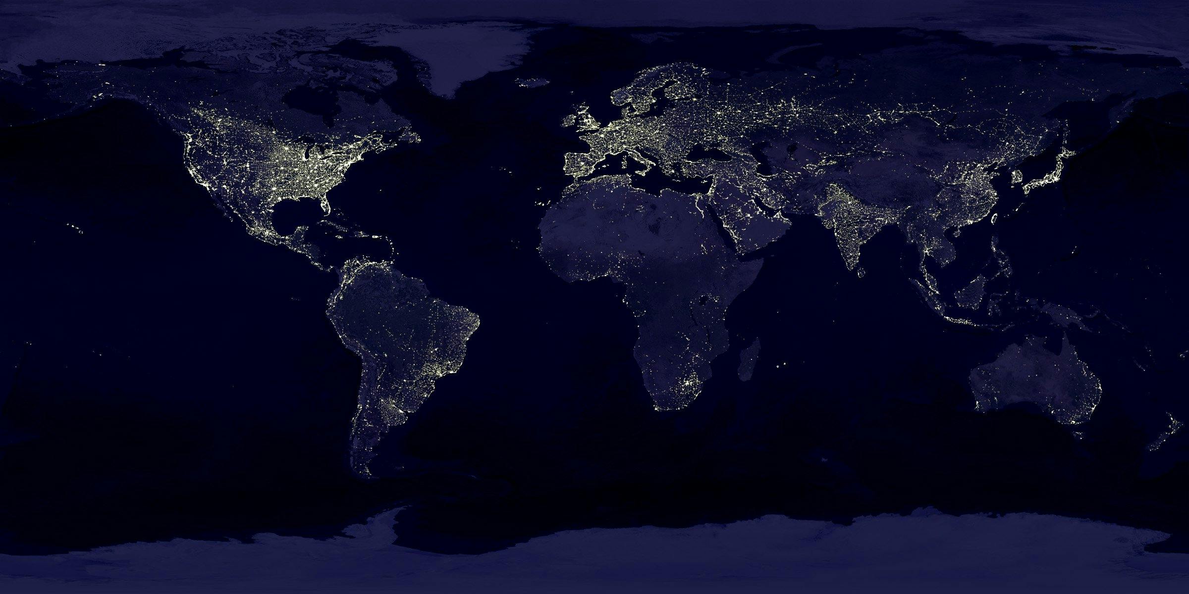 Satellite view of Earth at night with illuminated cities across continents.